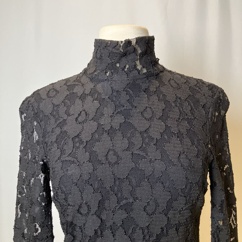 Black lace dress on a mannequin against a neutral background