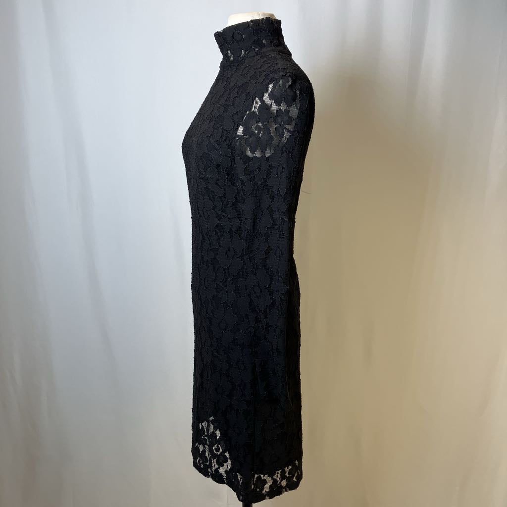 Black lace dress on a mannequin against a white background