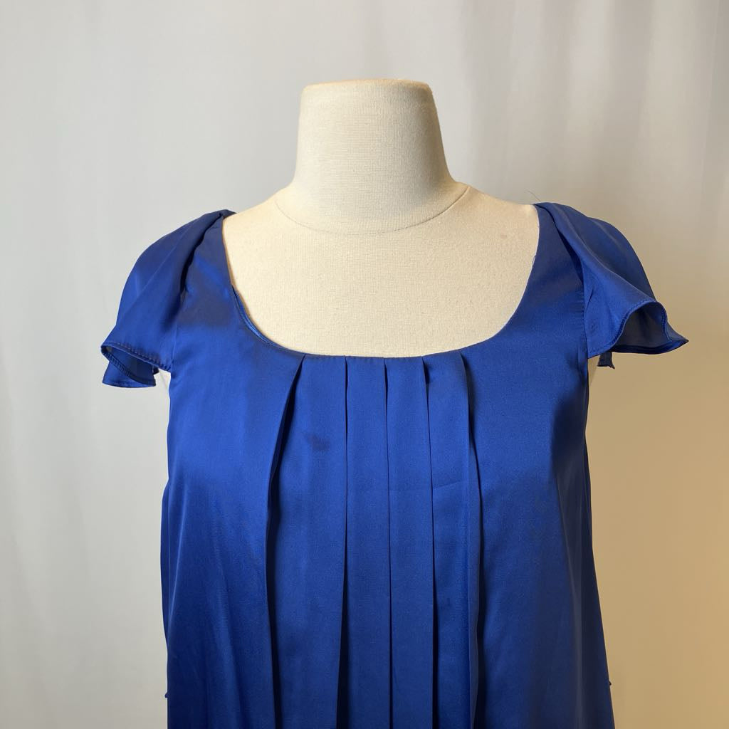 Blue dress on a mannequin against a plain background