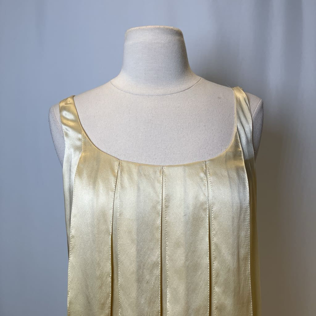 Gold satin dress on a mannequin against a plain background