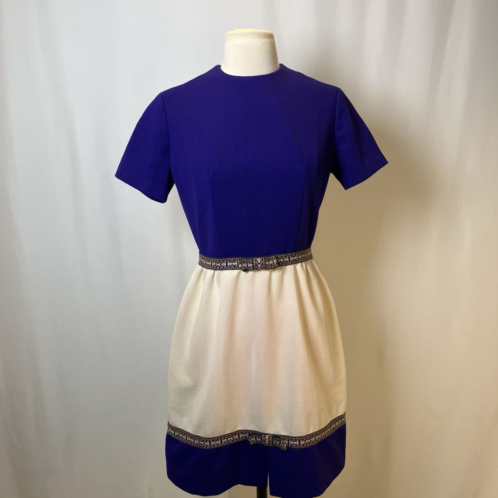 Mannequin wearing a two-tone dress with a blue top and beige skirt against a plain background