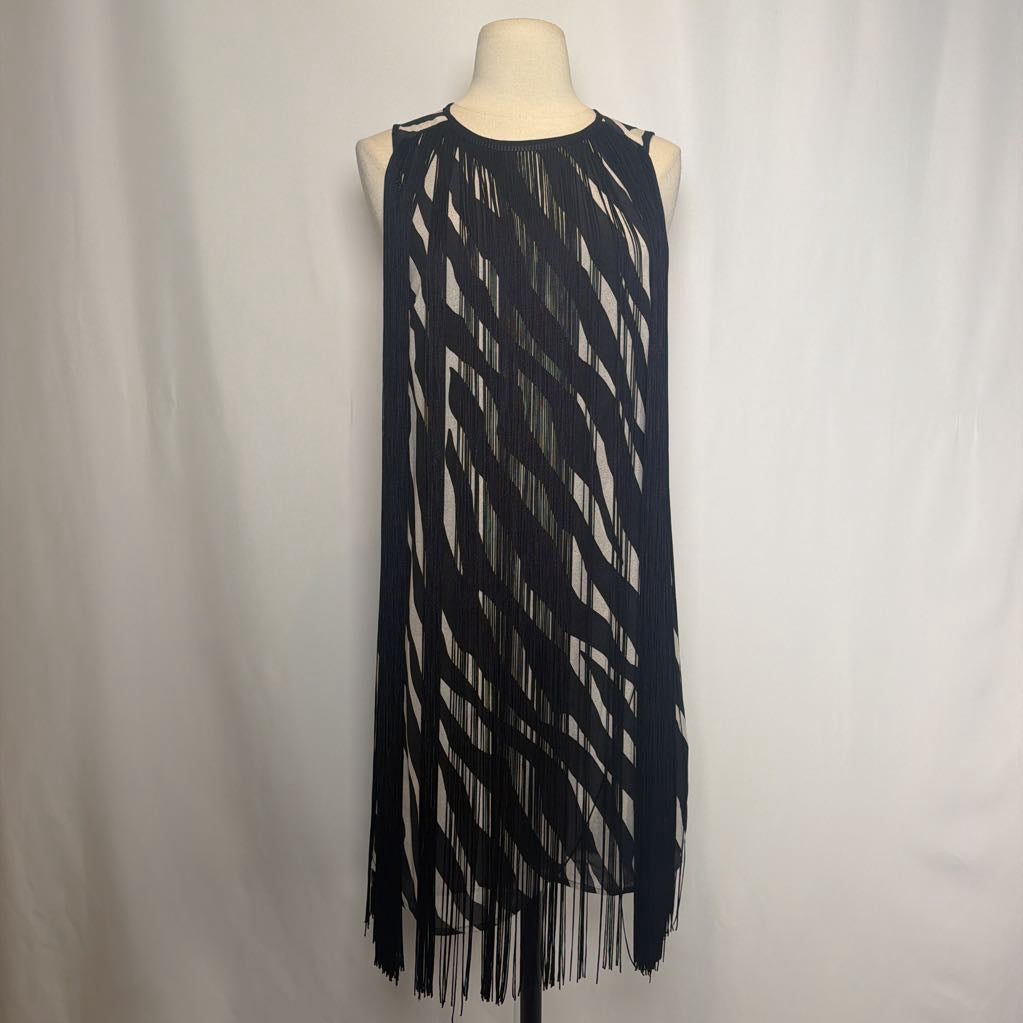 Zebra print dress with black fringe on a mannequin in front of a white wall.