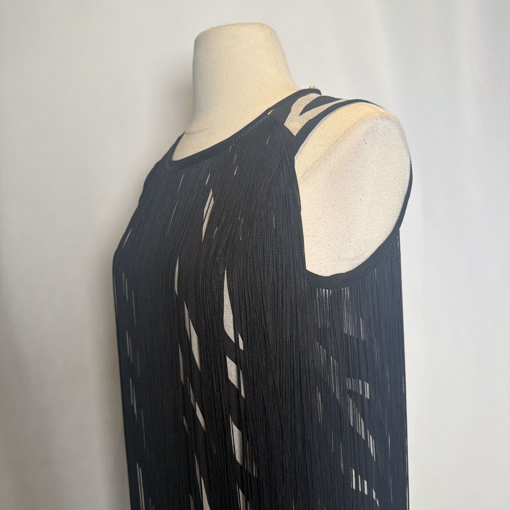 Zebra print dress with black fringe on a mannequin in front of a white wall.