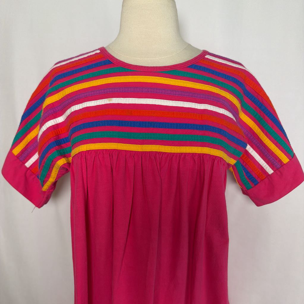Pink ruffled maxi dress with striped design on a mannequin in front of a white wall.