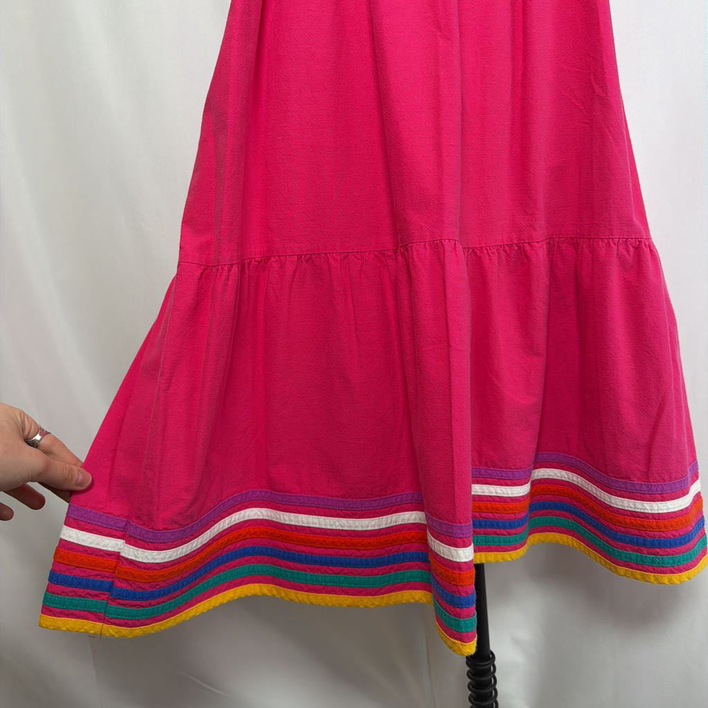 Pink ruffled maxi dress with striped design on a mannequin in front of a white wall.
