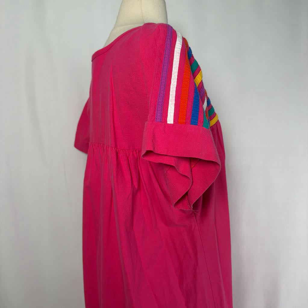 Pink ruffled maxi dress with striped design on a mannequin in front of a white wall.