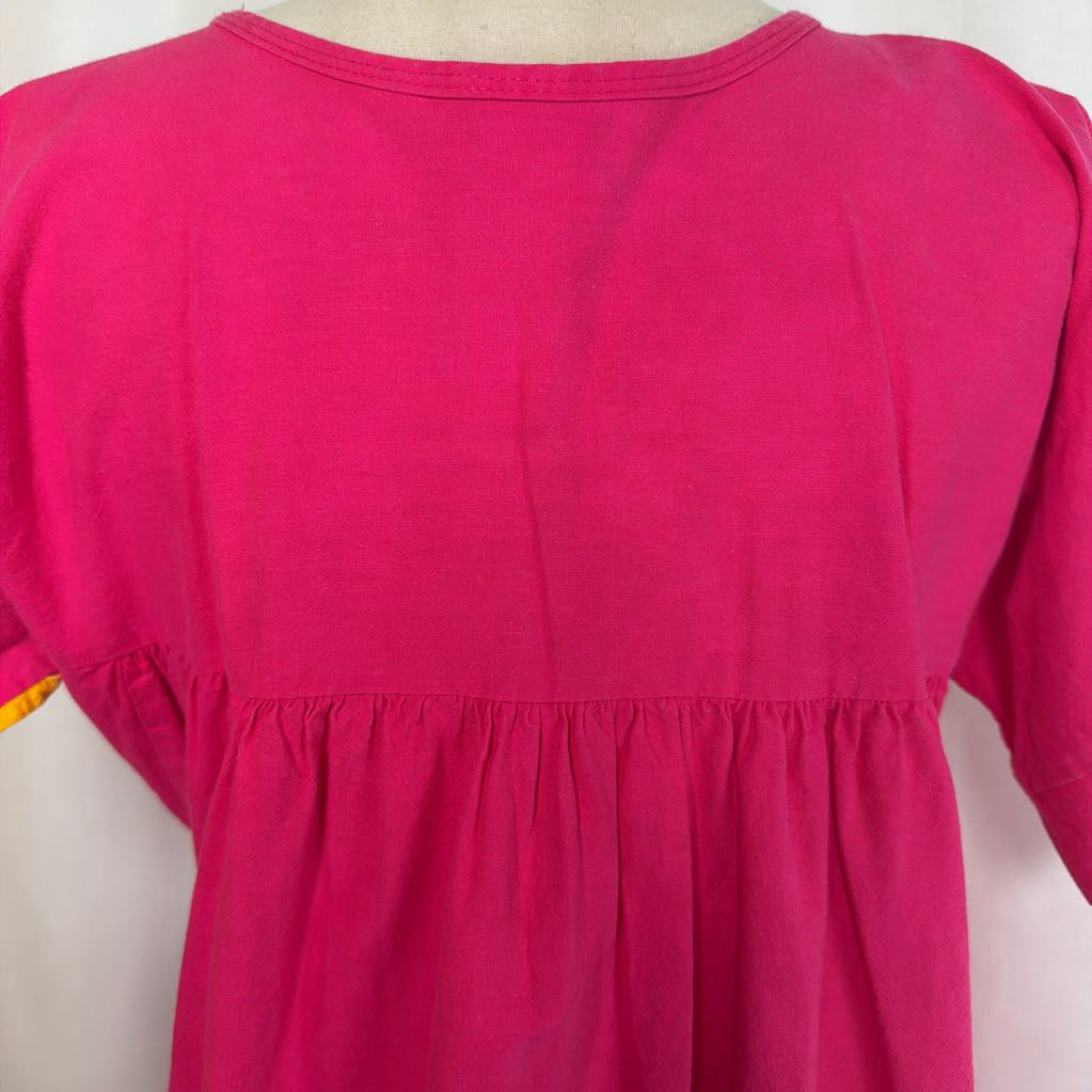 Pink ruffled maxi dress with striped design on a mannequin in front of a white wall.