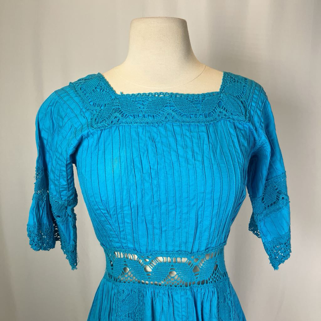 Blue dress on a mannequin against a plain background