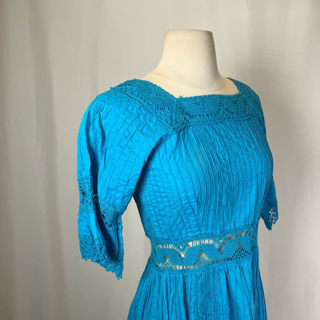 Blue dress on a mannequin against a plain background