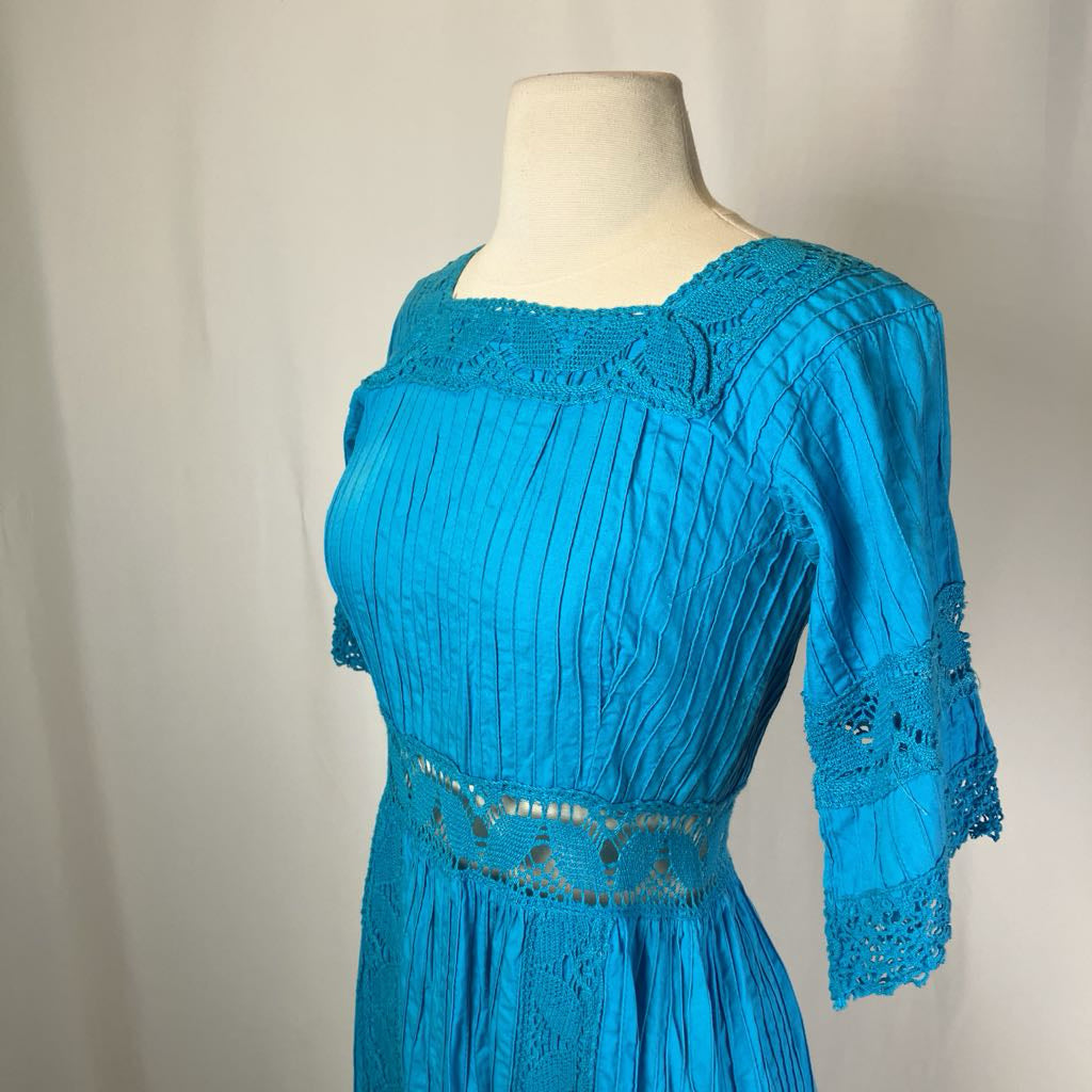 Blue dress on a mannequin against a plain background