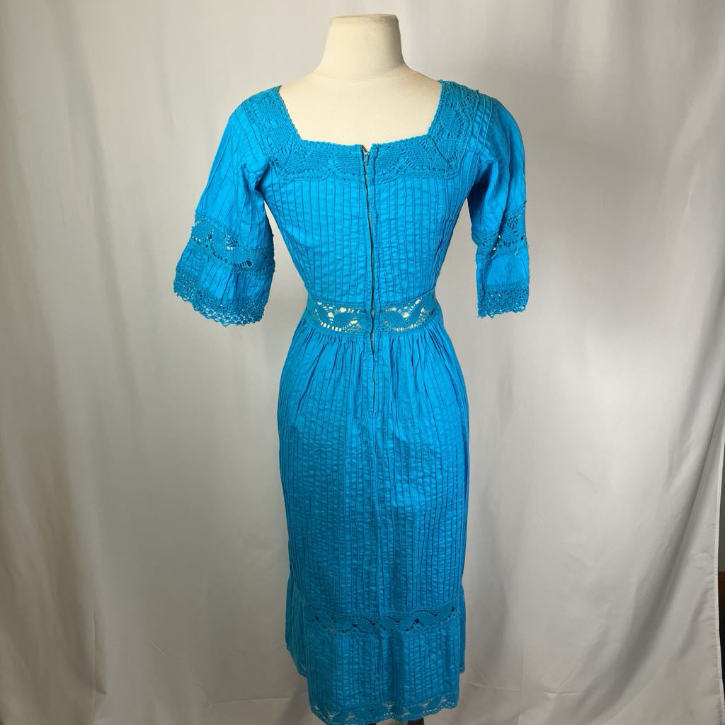 Blue dress on a mannequin against a plain background