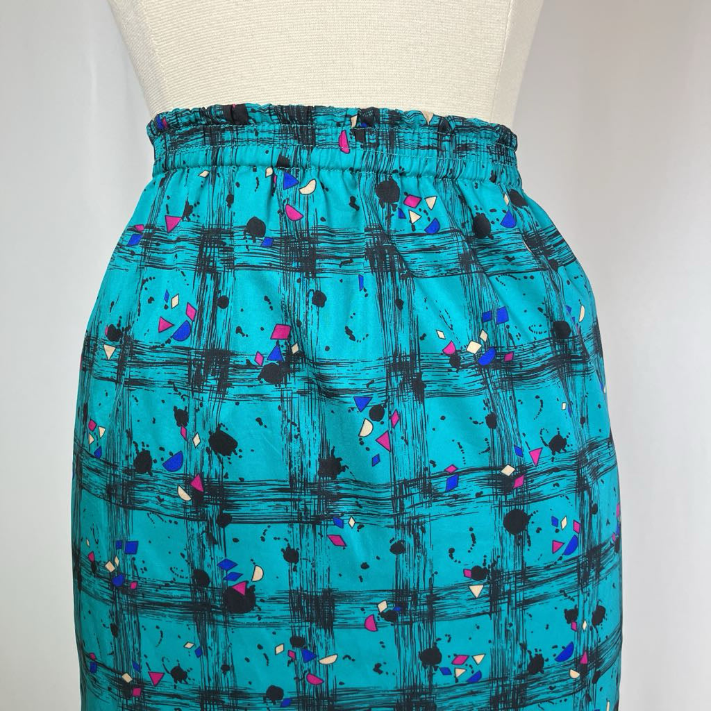 Teal skirt with black abstract pattern on a mannequin against a white background