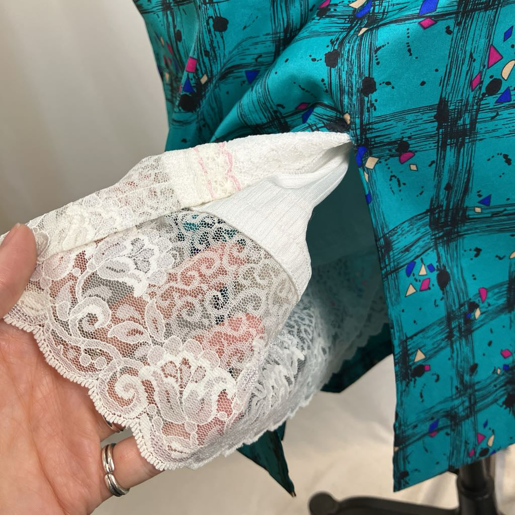 Hand holding white lace fabric next to a blue patterned garment