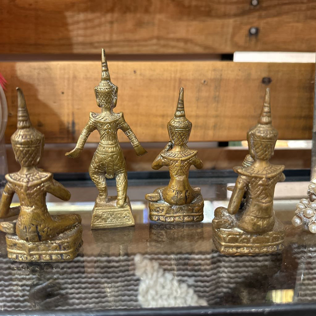 Set of gold figurines on a reflective surface with a wooden background