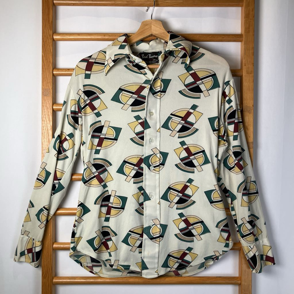 Patterned shirt on a wooden hanger against a white wall