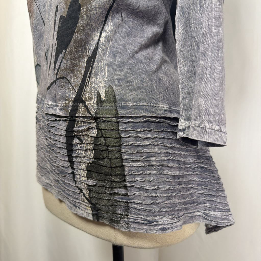 Gray tunic dress with an abstract design on a mannequin in front of a white wall.
