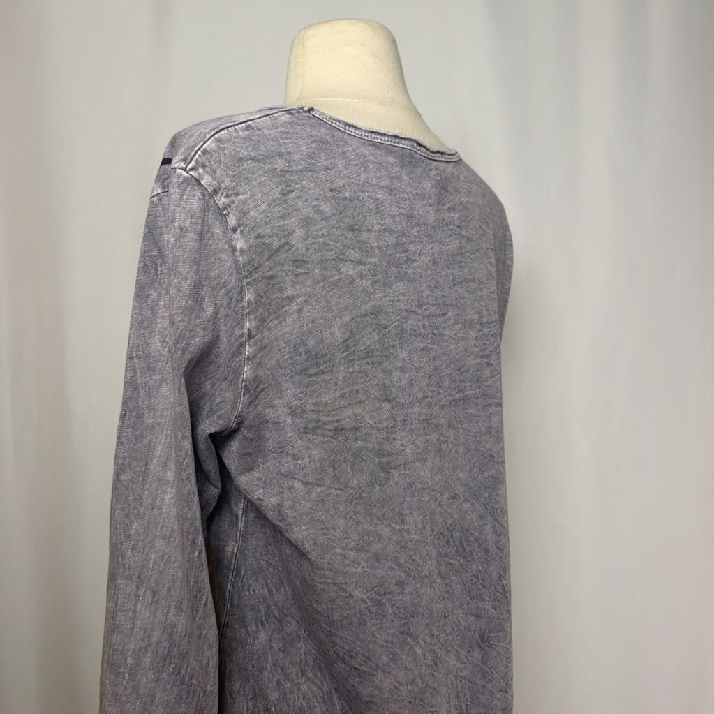 Gray tunic dress with an abstract design on a mannequin in front of a white wall.