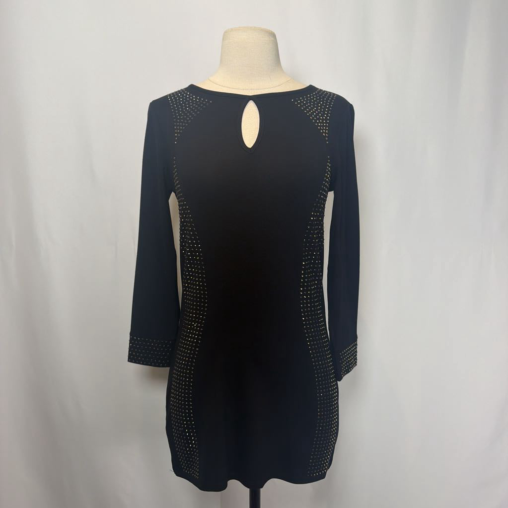 Black dress with rhinestone embellishments on a mannequin in front of a white wall.
