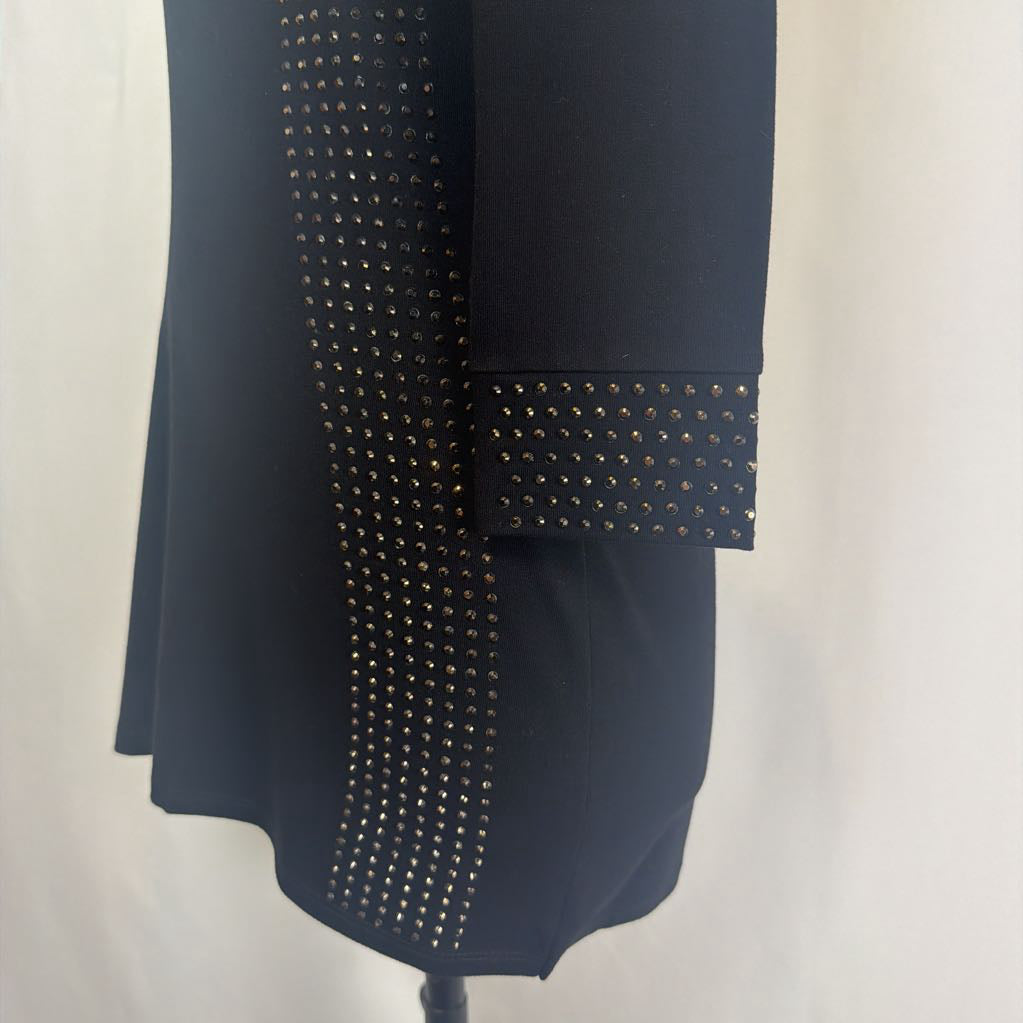 Black dress with rhinestone embellishments on a mannequin in front of a white wall.