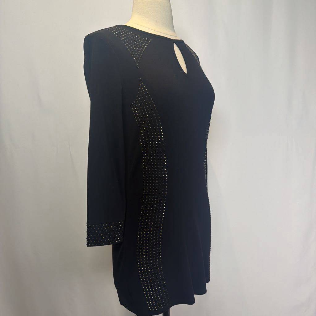 Black dress with rhinestone embellishments on a mannequin in front of a white wall.