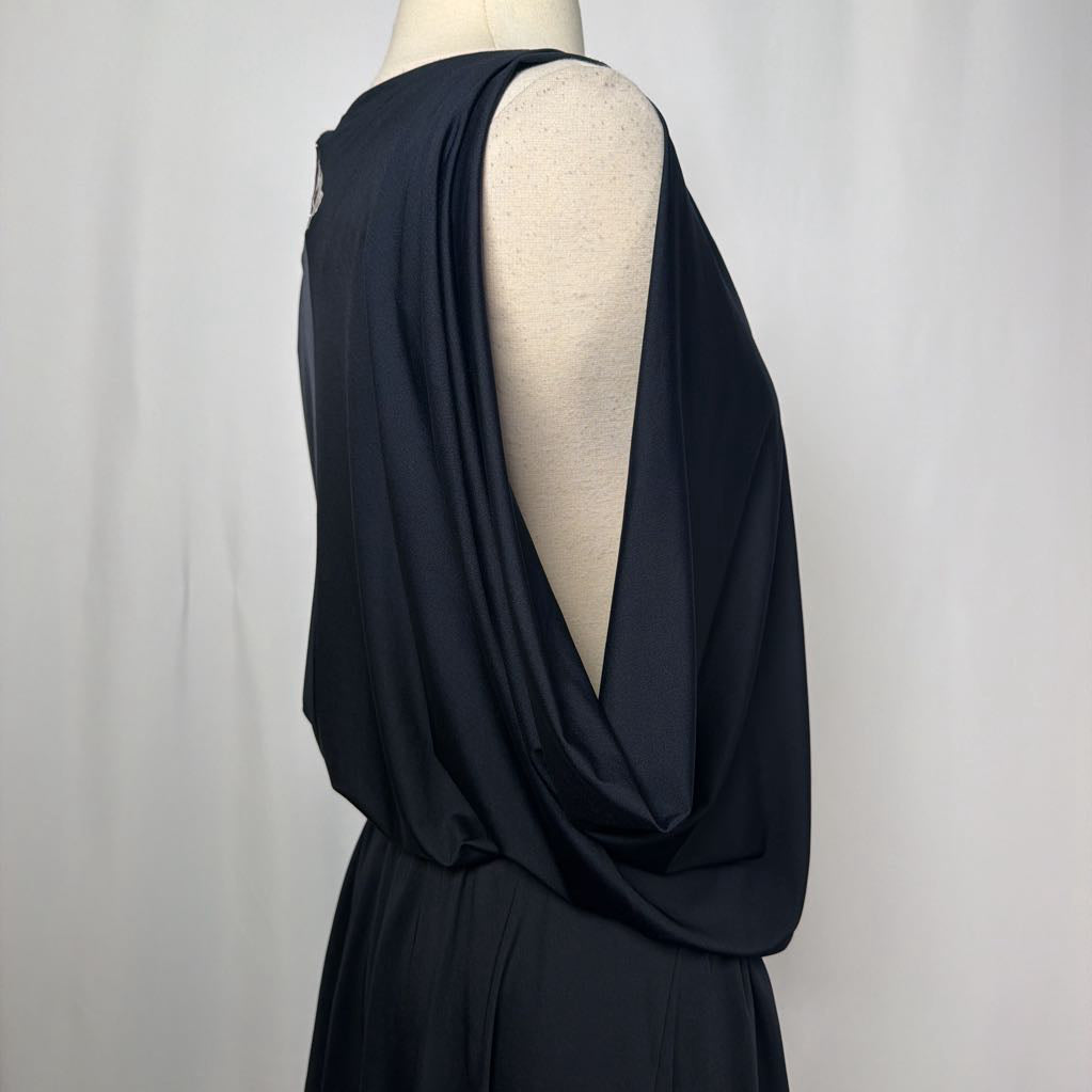 black dress with gold button details against white backdrop