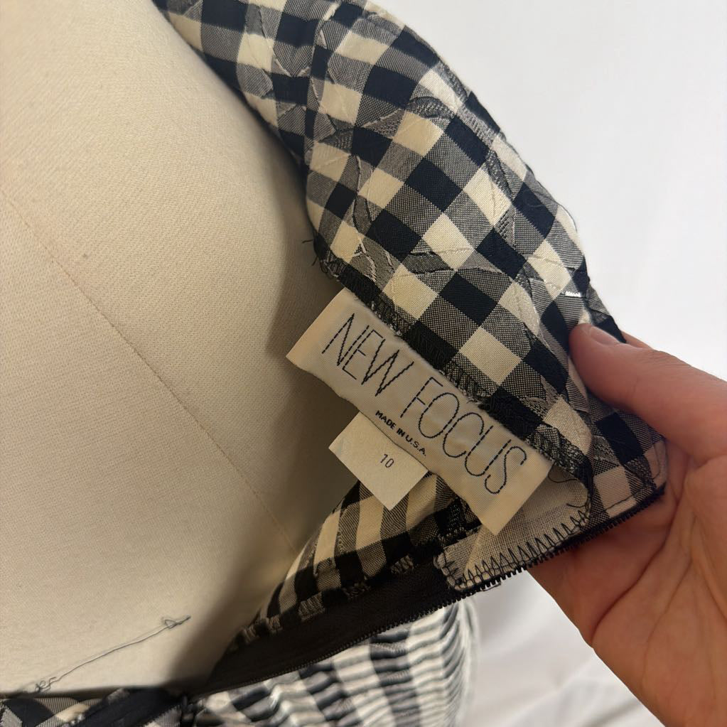 Hand holding a New Focus brand tag on a skirt.
