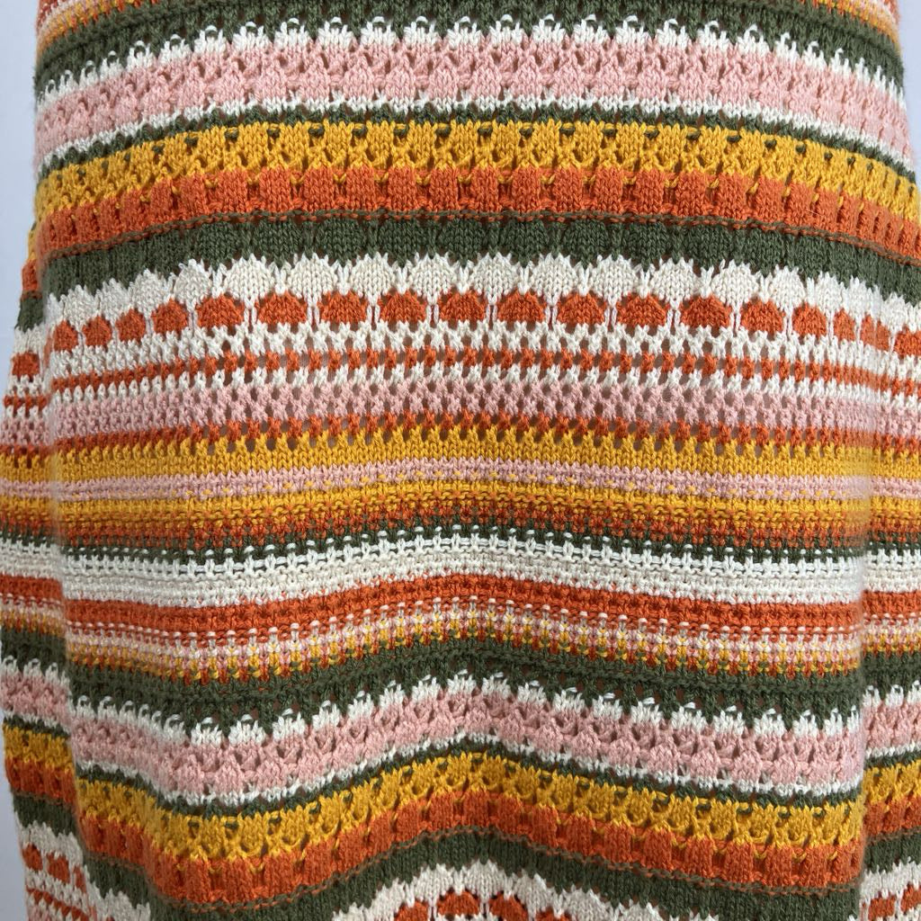 Close-up of a crocheted fabric with multicolored stripes on a white background