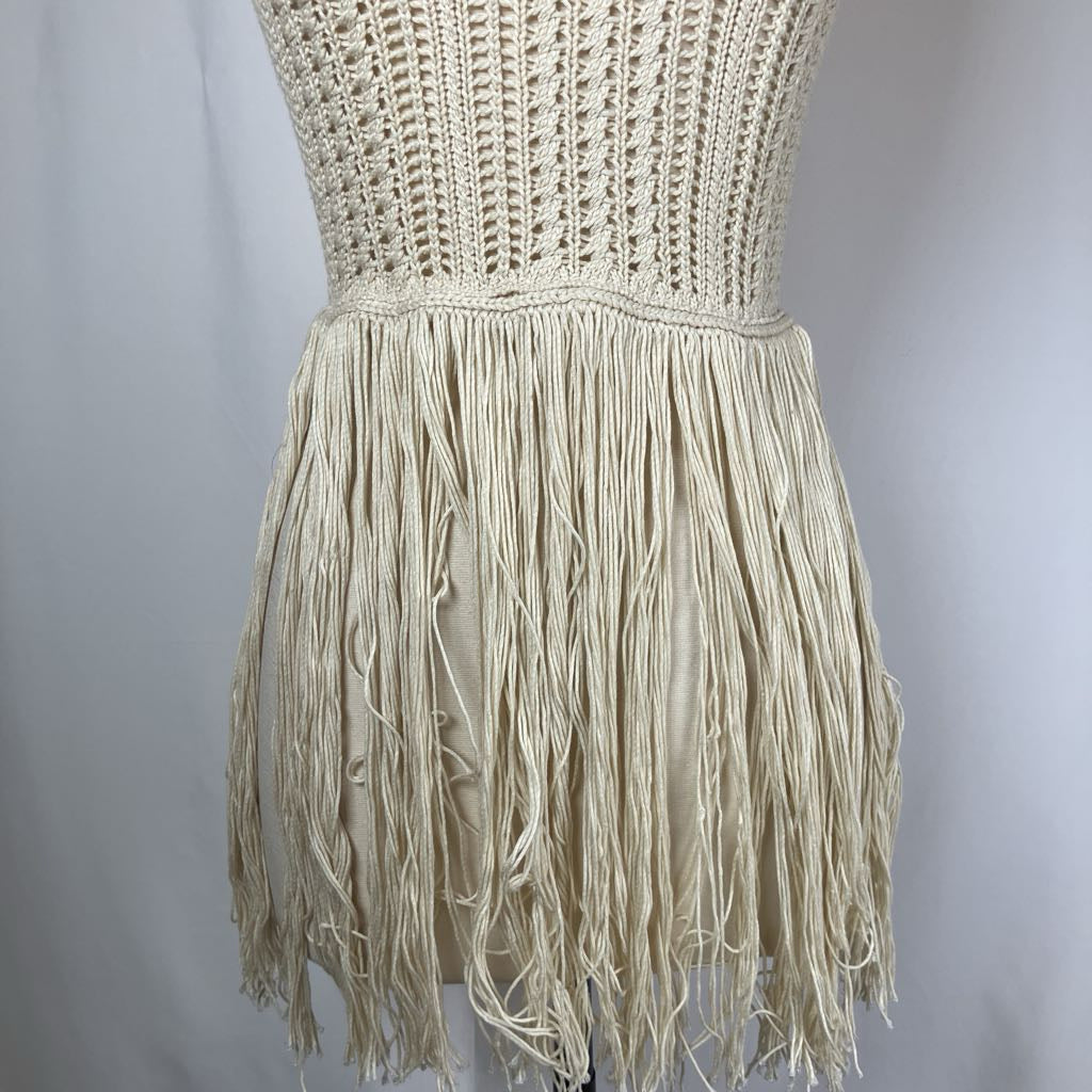 Beige crochet top with fringe skirt on a plain background