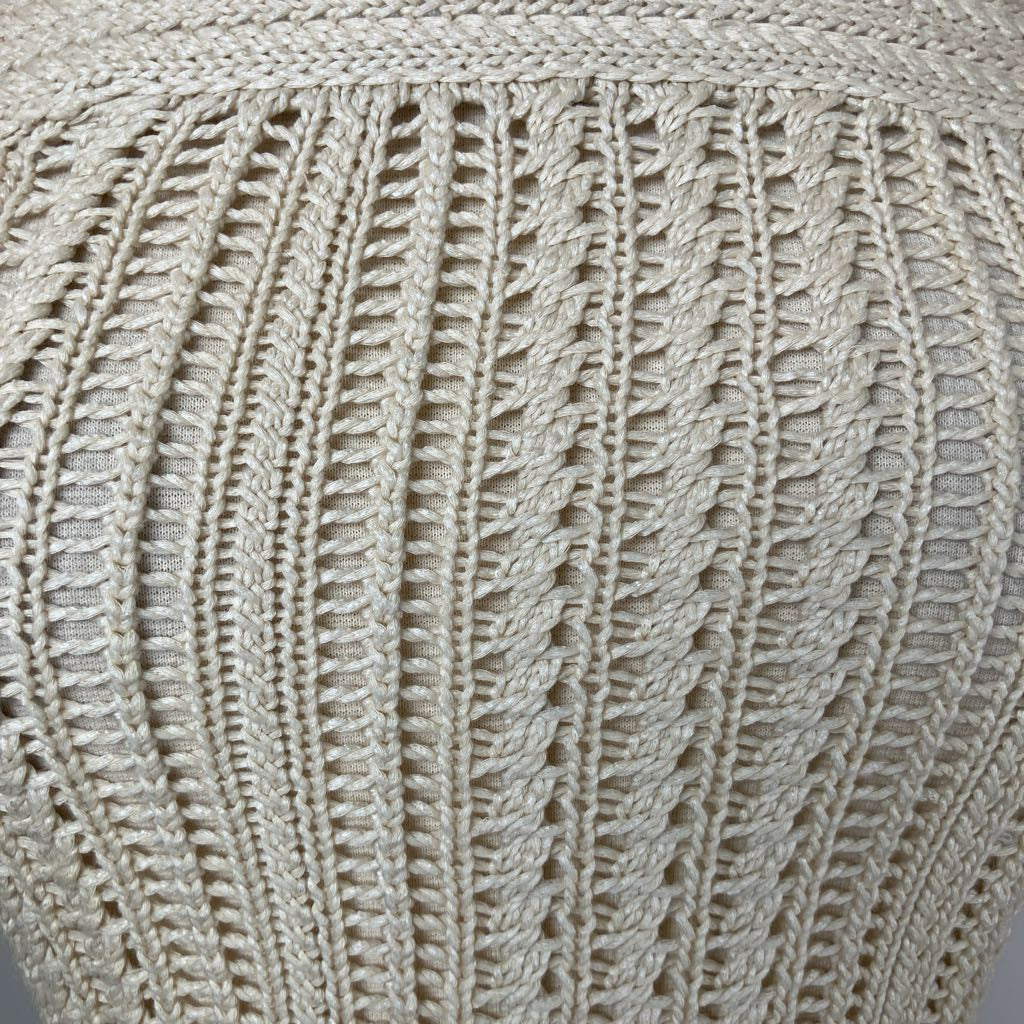 Close-up of a textured beige fabric with a patterned weave.