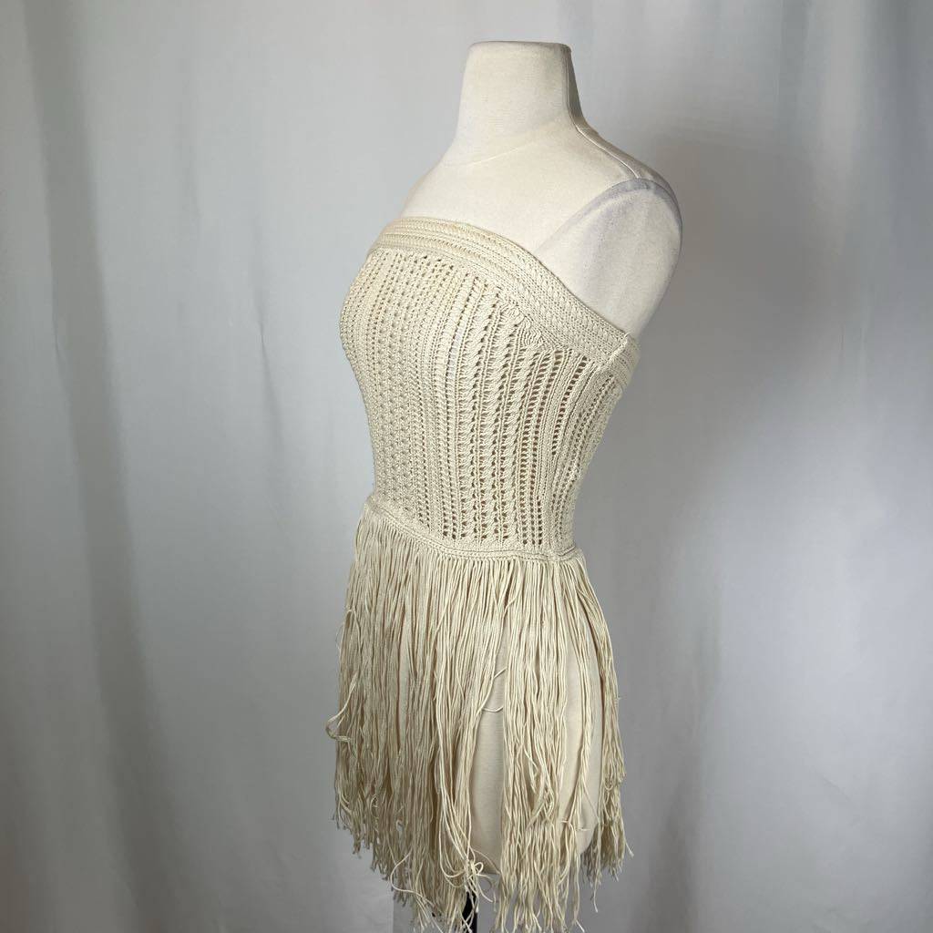 Beige strapless dress with fringe on a mannequin against a plain background