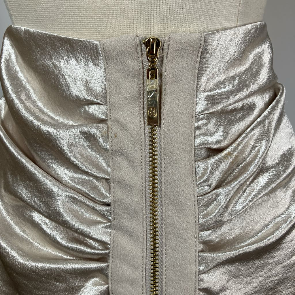 Close-up of a silver metallic dress with a gold zipper on a mannequin.