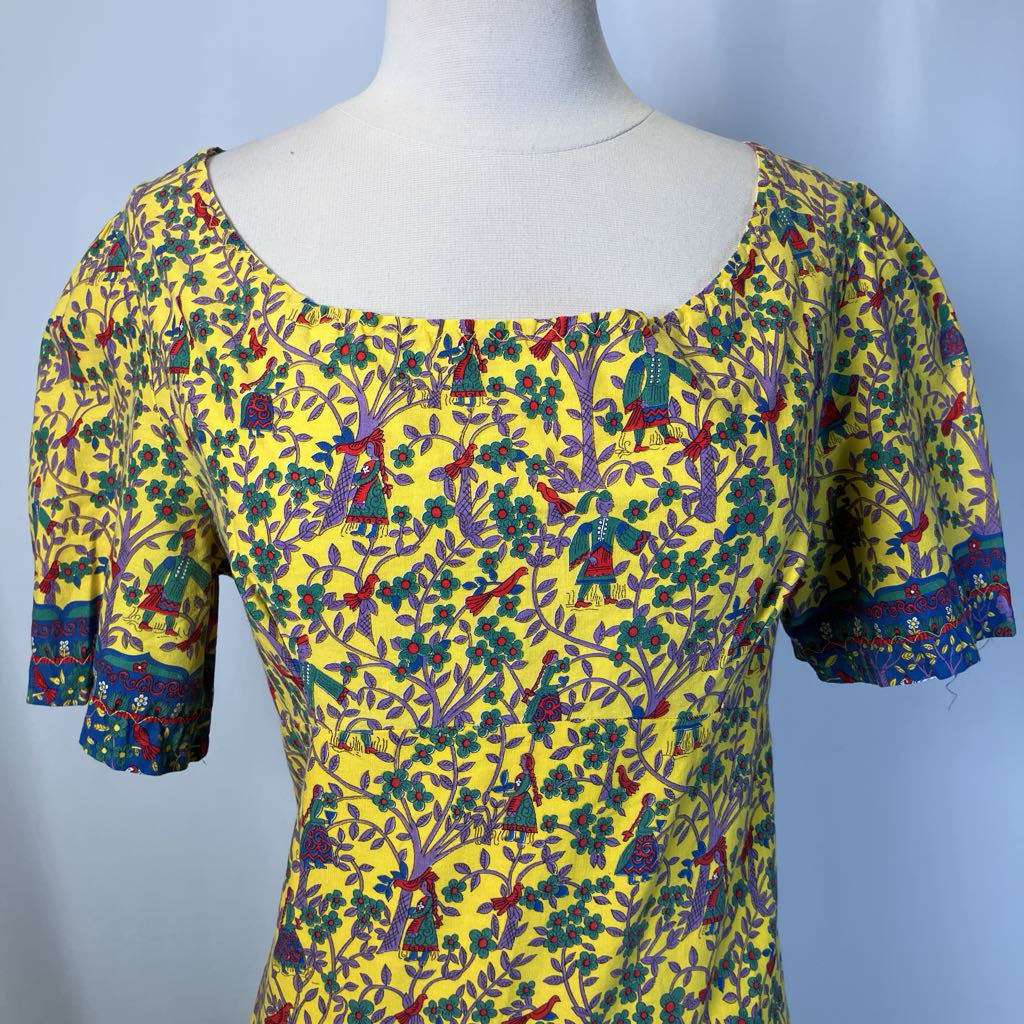 Mannequin wearing a colorful patterned dress with a yellow background