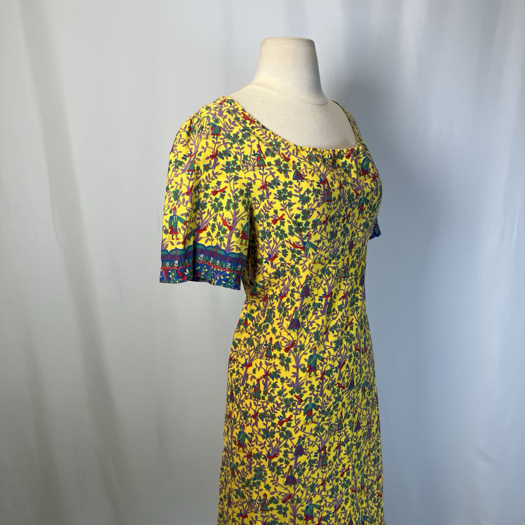 Colorful dress with a floral pattern on a mannequin against a plain background