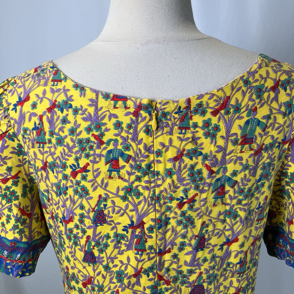 Colorful patterned blouse on a mannequin against a plain background