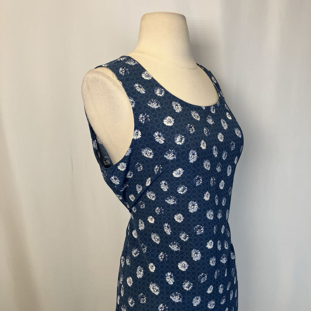 Navy blue sleeveless dress with white floral pattern on a mannequin against a plain background