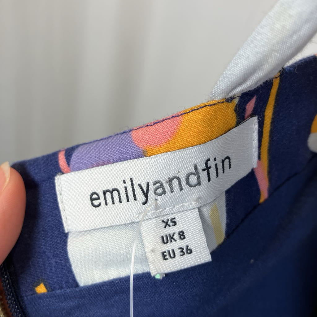Fabric tag with 'emilyandfin' brand name on a garment with colorful pattern
