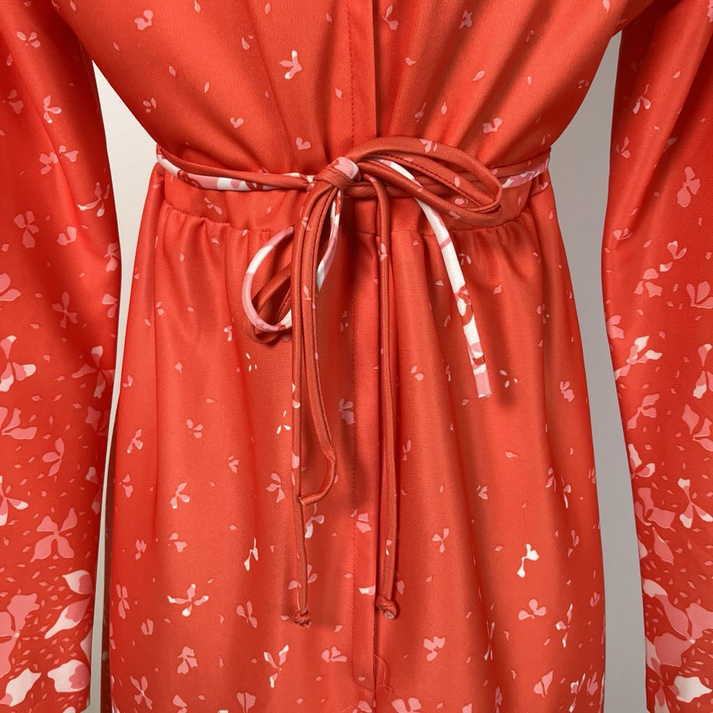 Back of the red dress with white floral pattern on a gray background