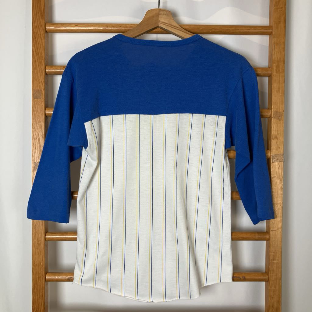 Blue and white striped shirt on a wooden hanger against a white wall.
