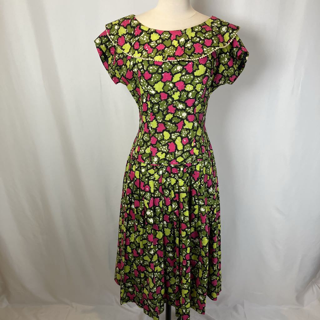 Green floral dress on a mannequin against a white background