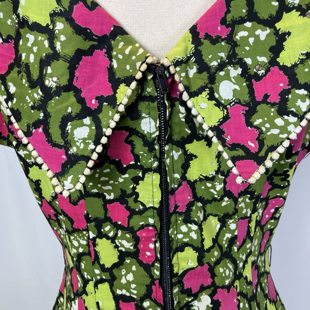 Colorful patterned garment with a zipper on a mannequin against a light background