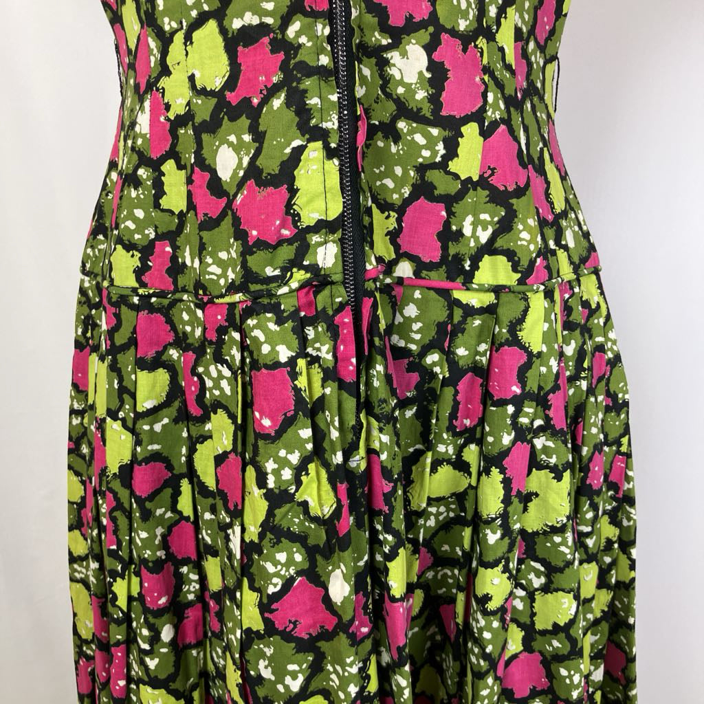Dress with a vibrant pattern of pink flowers on a green background