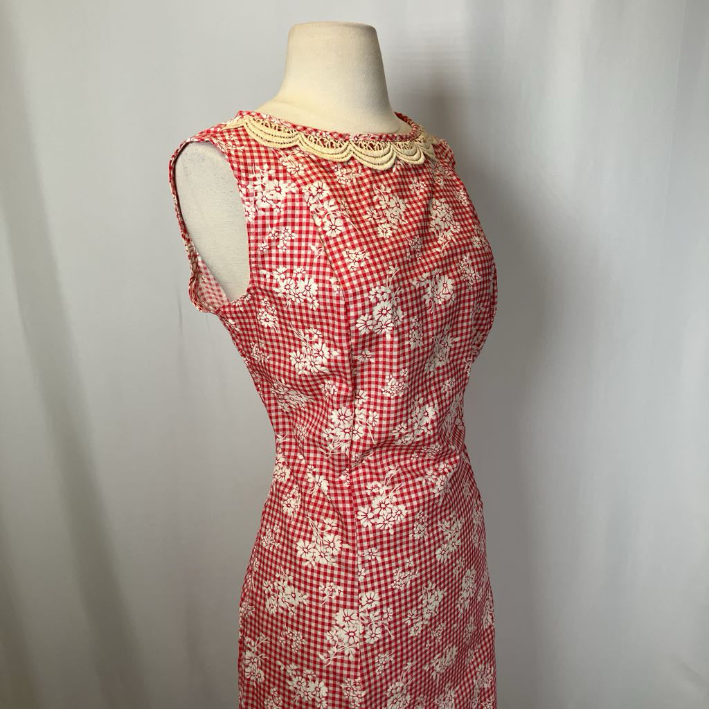 Red and white checkered dress with floral patterns on a mannequin against a plain background