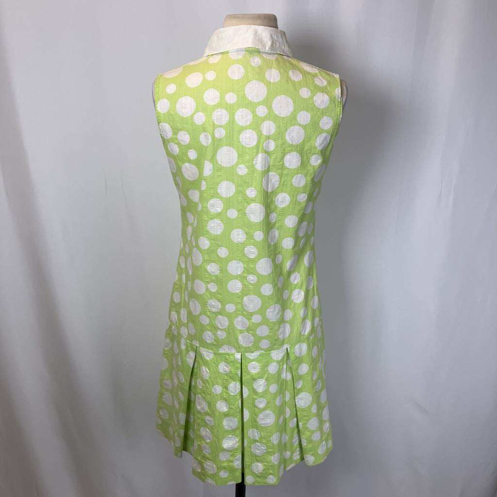 Green dress with white polka dots on a mannequin against a plain background
