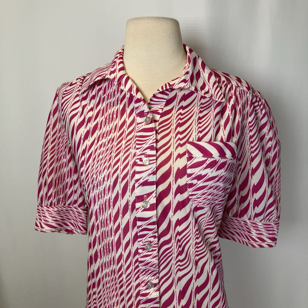 Red and white patterned dress on a mannequin against a plain background