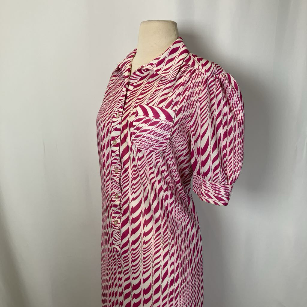 Mannequin wearing a pink and white patterned dress against a plain background