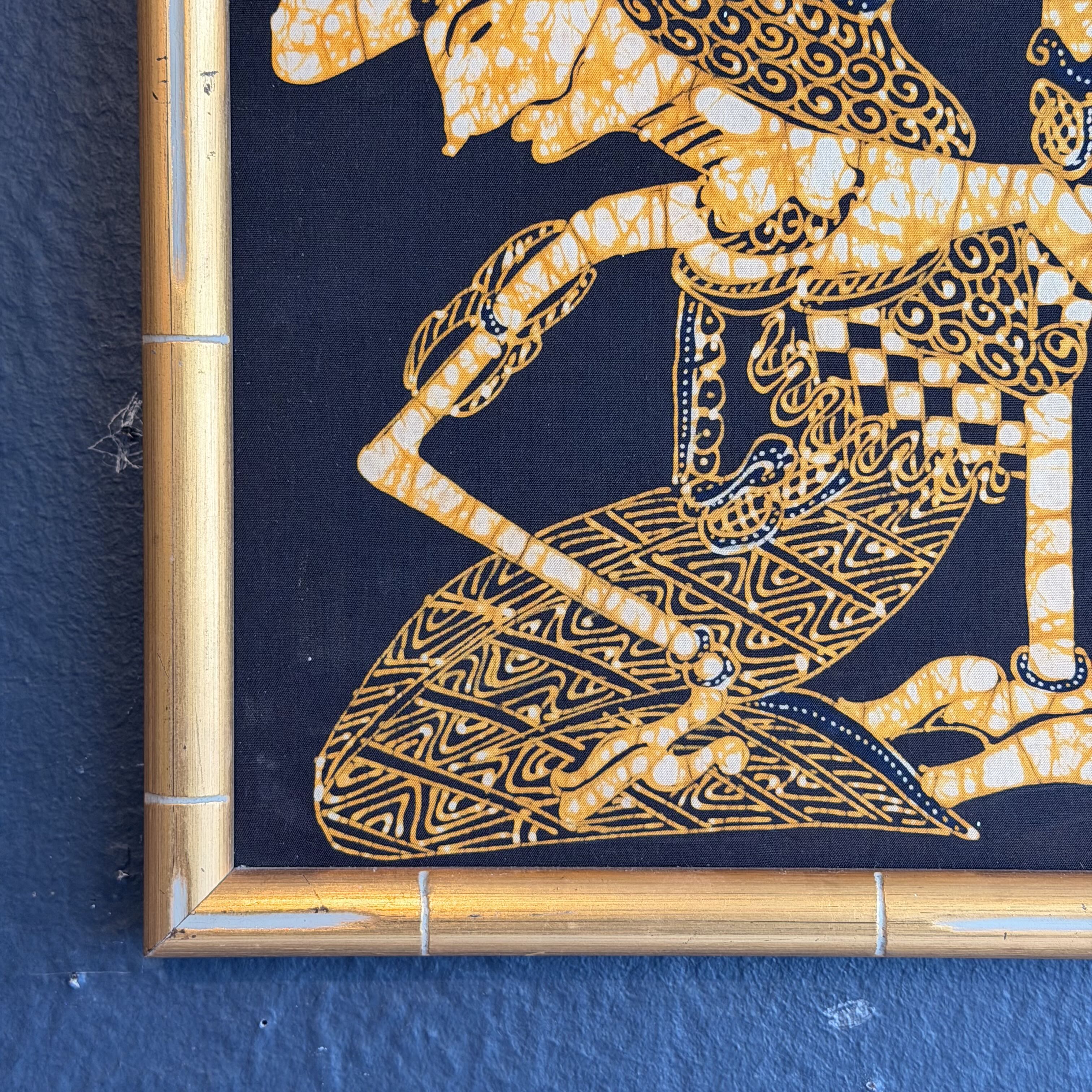 Decorative wall art with gold and blue design on a dark blue background