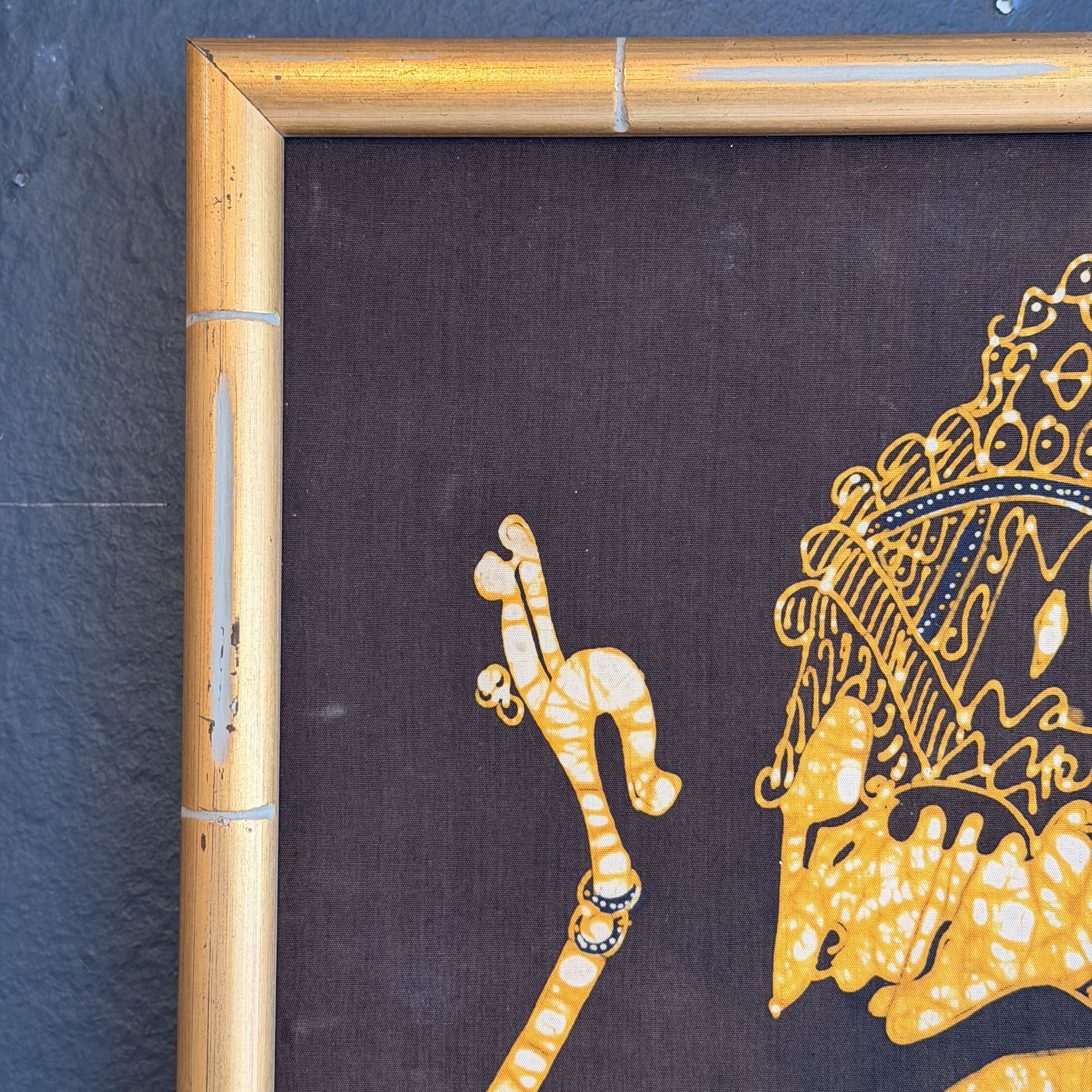 Framed artwork with a gold elephant and camel on a dark background