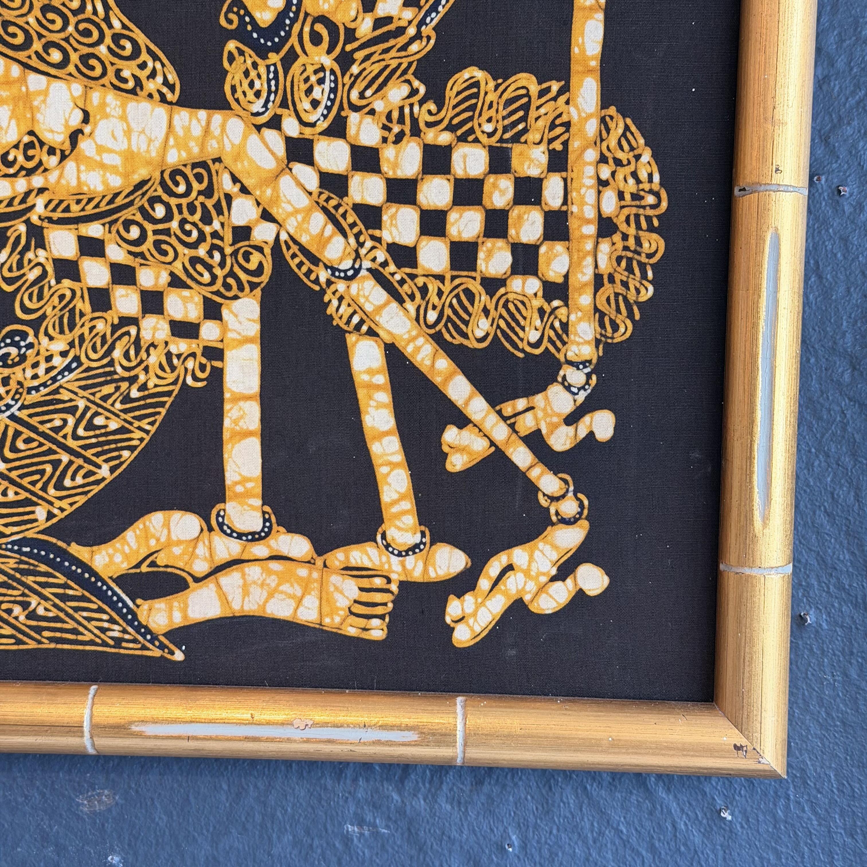 Decorative tray with gold and black pattern on a blue wall