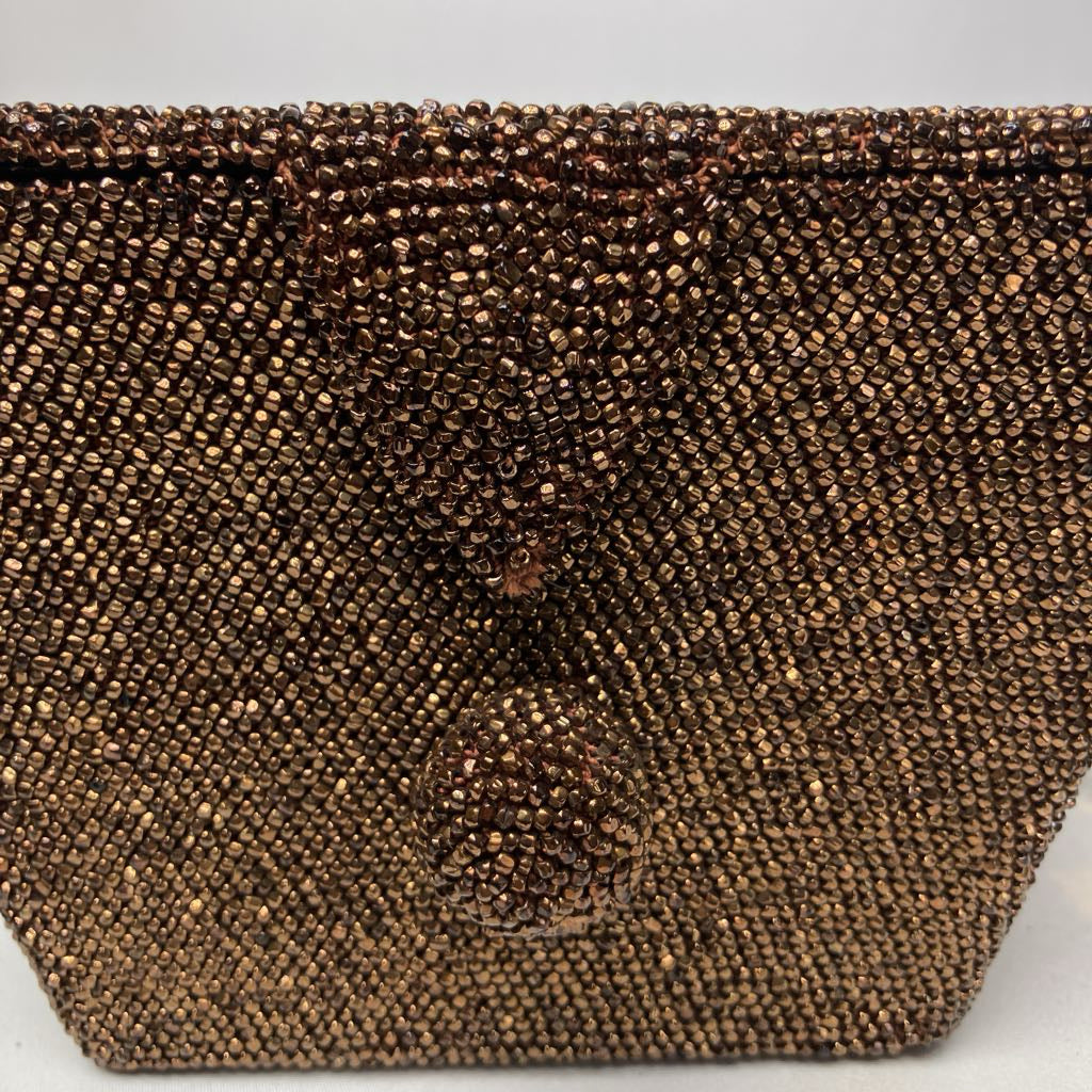 Close-up of a brown beaded clutch bag on a white background