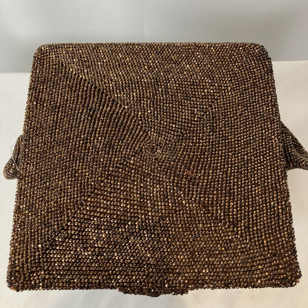 Brown beaded clutch bag on a light background